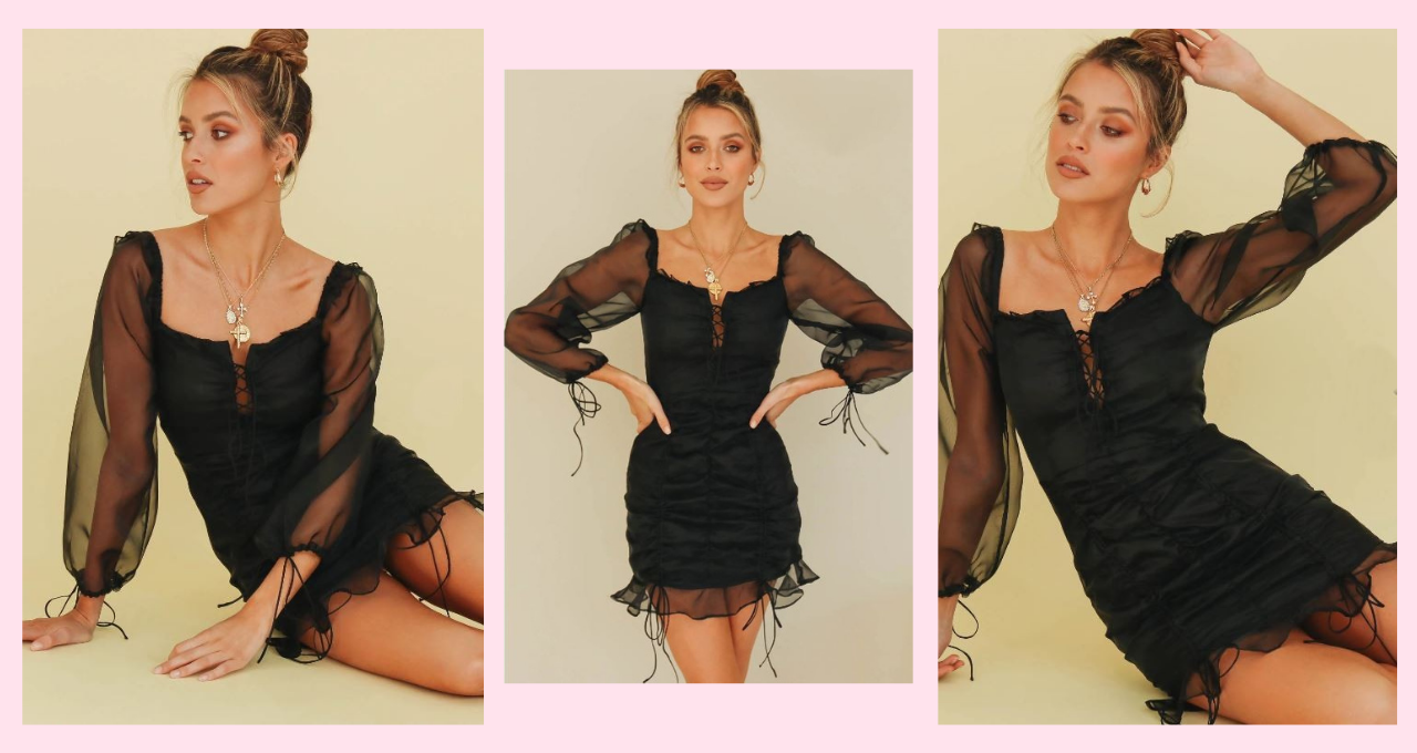 Model is wearing Sheer Organza Black Mini Dress with ruched bodice and sheer long sleeves.